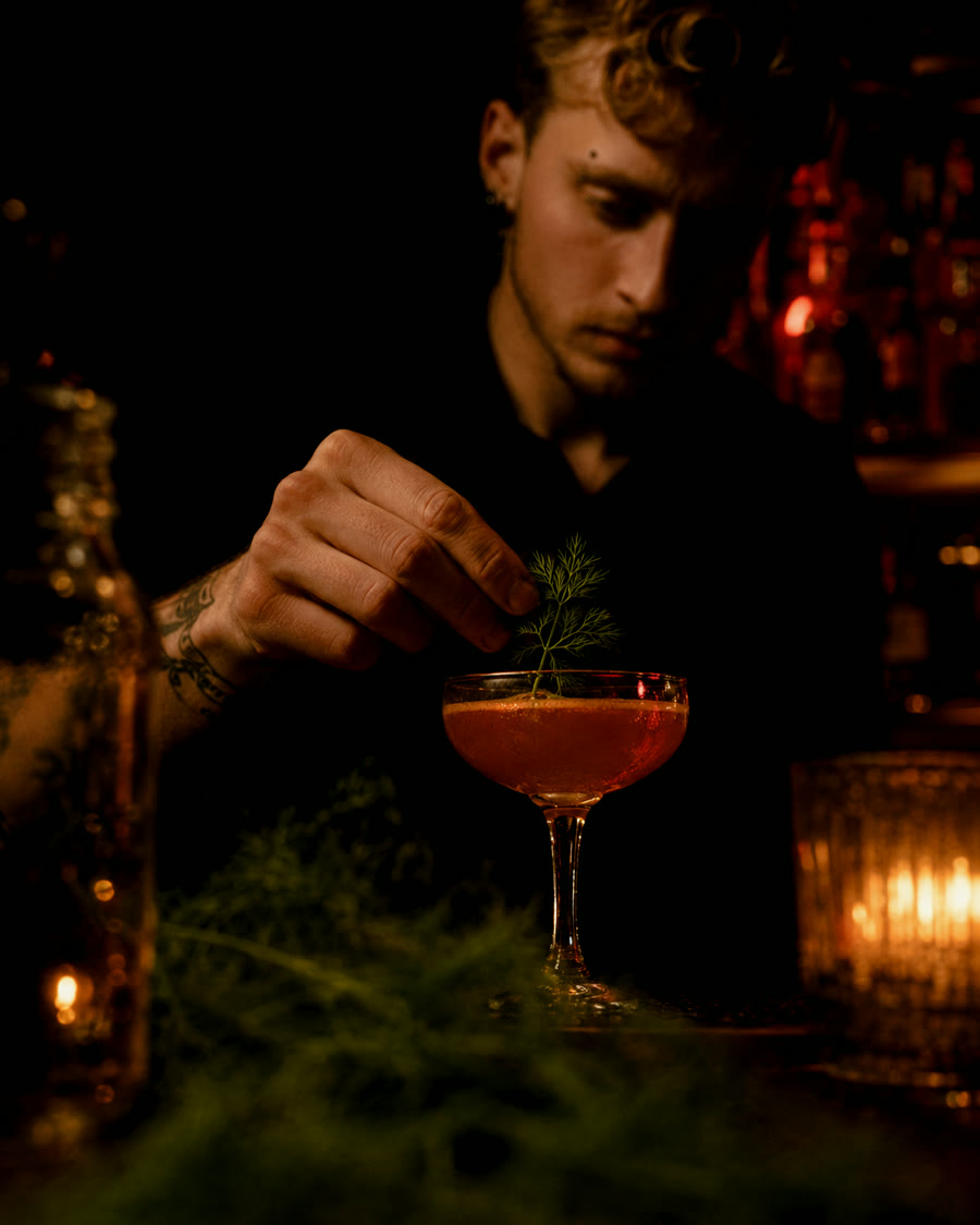 Bartender finishing the Carrot & Dill with a fresh dill frond